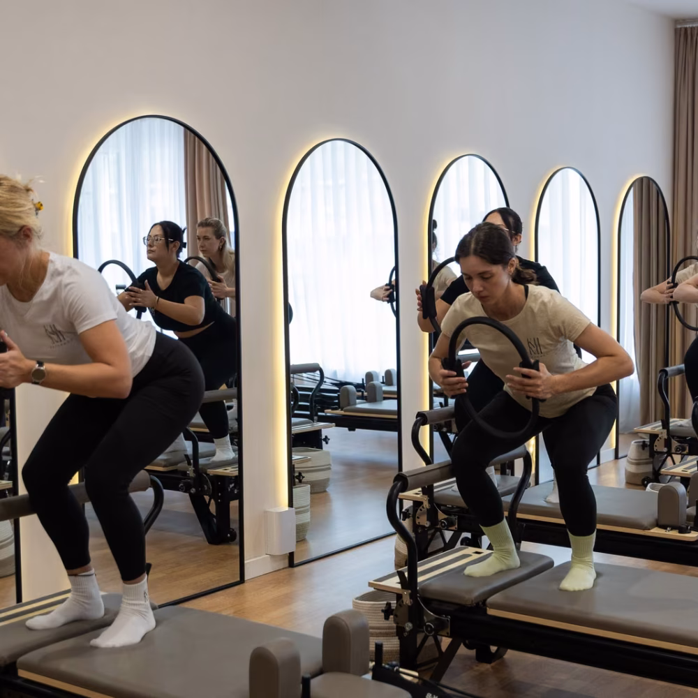 Kniebeuge mit Pilates-Ring am Reformer